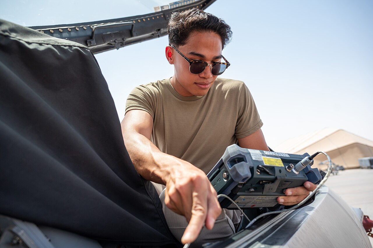 Aircraft technician performing an inspection with a handheld testing device